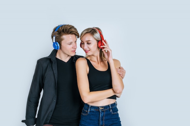 Счастливая молодая пара в наушниках слушает музыку