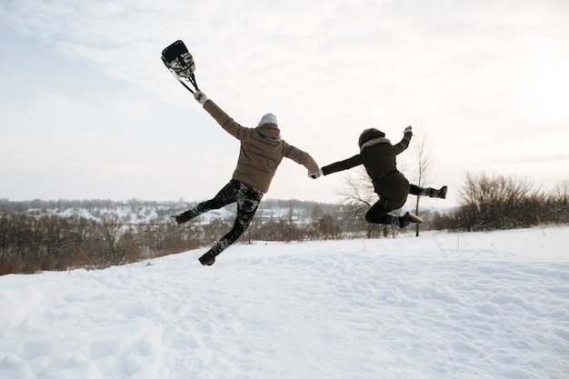 恋​の​幸せな​若い​カップル​は​喜び​の​ために​飛び降りています​。​冷たい​雪​の​冬​の​日​。​冬​の​ラブストーリー​。