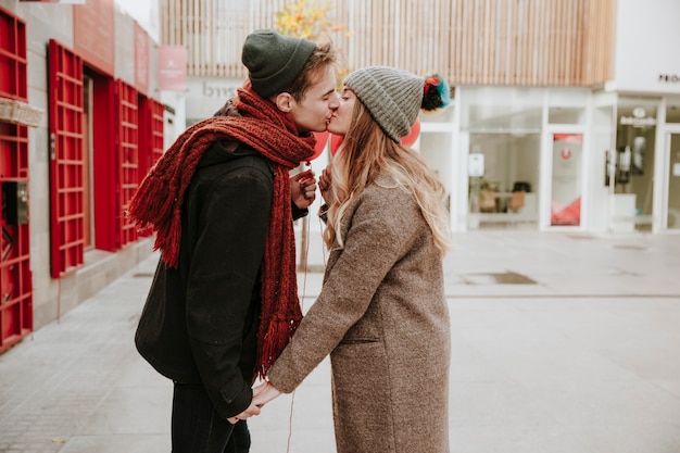 幸せな若いカップルは、通りにキス