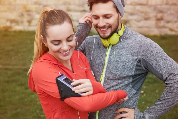 Happy young couple listening music with earphones