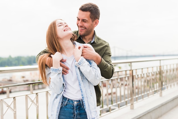 Happy young couple in love standing near metallic railing