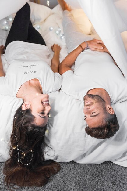 Happy young couple lying on bed