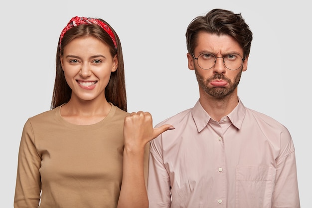 happy young couple posing against the white wall