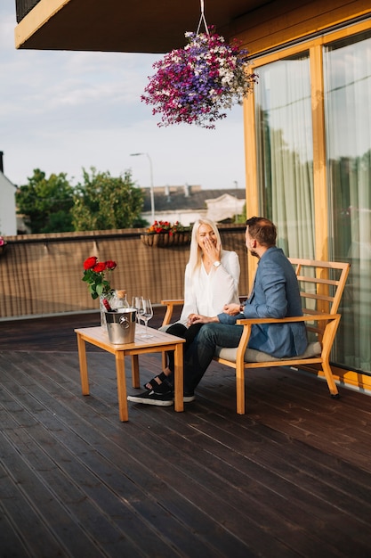 Free photo happy young couple sitting on rooftop enjoying dating