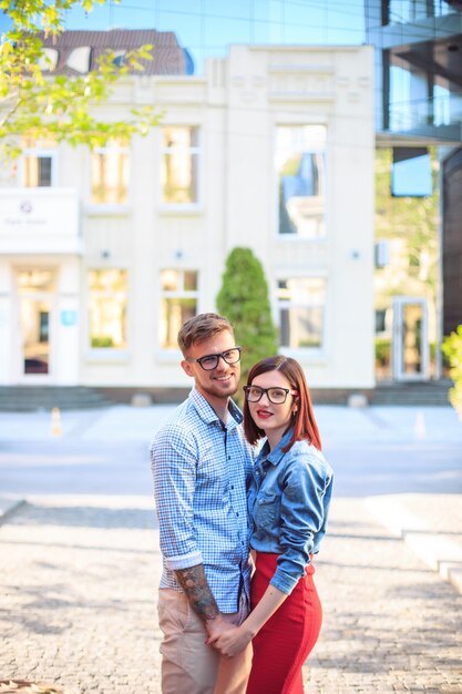 Happy young couple standing at street of city and laughing on the bright sunny day