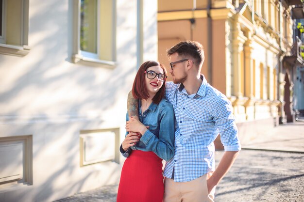 Happy young couple standing at street of city and laughing on the bright sunny day