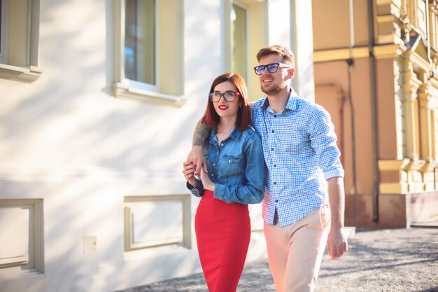 Happy young couple standing at street of city and laughing on the bright sunny day