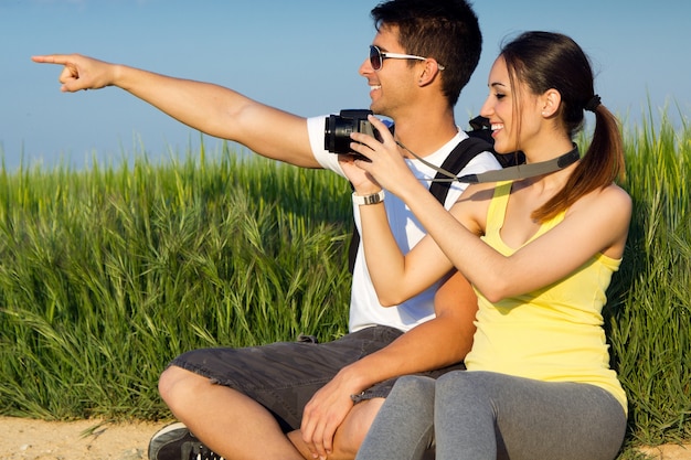 Free photo happy young couple taking photos in the field