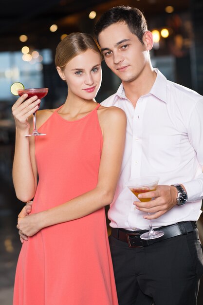 Happy Young Couple with Cocktails at Party
