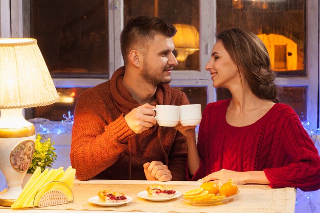 happy young couple with cups of tea