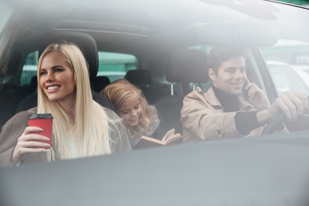 Счастливая молодая семья в машине