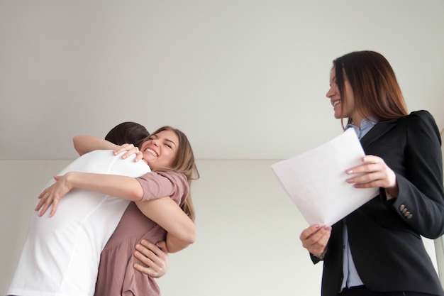 Free photo happy young family couple embracing, just bought new apartment house