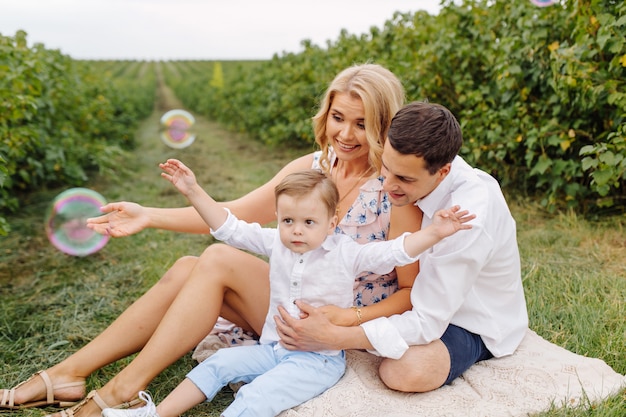 Счастливая молодая семья Папа, мама и маленький сын выглядят счастливыми в парке