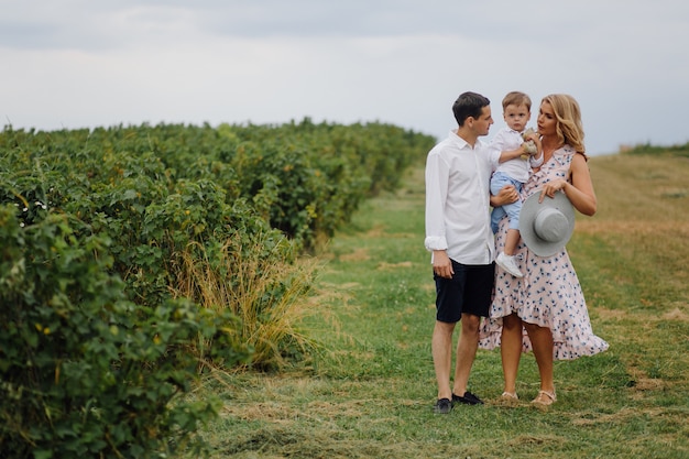 Foto gratuita felice giovane famiglia papà, mamma e figlio piccolo sembra felice nel parco