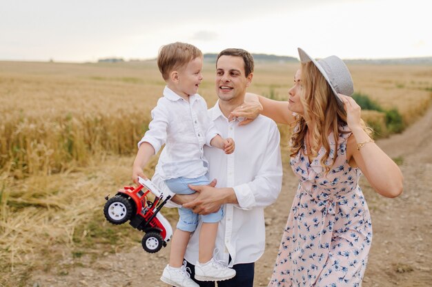 Счастливая молодая семья Папа, мама и маленький сын выглядят счастливыми в парке