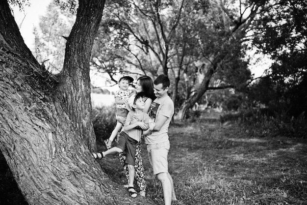 Счастливая молодая семья мать отец двое детей сын на природе весело