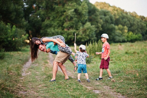 Happy young family mother father two children son on nature having fun