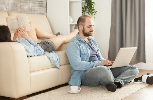 リビングルームでリラックスして幸せな若い家族