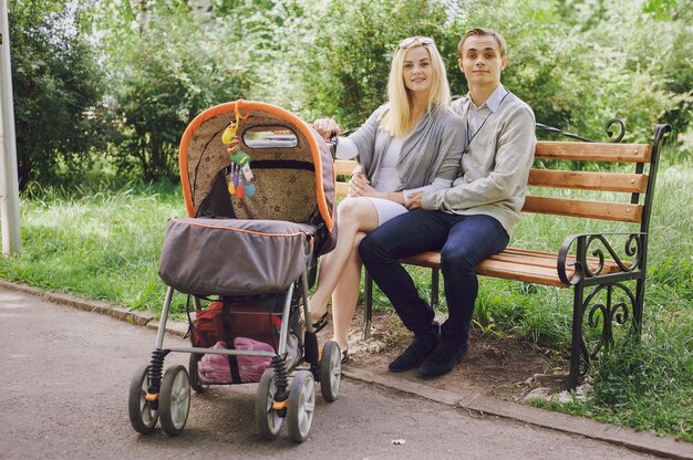 公園のベンチに座って幸せな若い家族