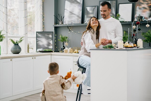 Happy young family spending time together in kitchen at home at christmas
