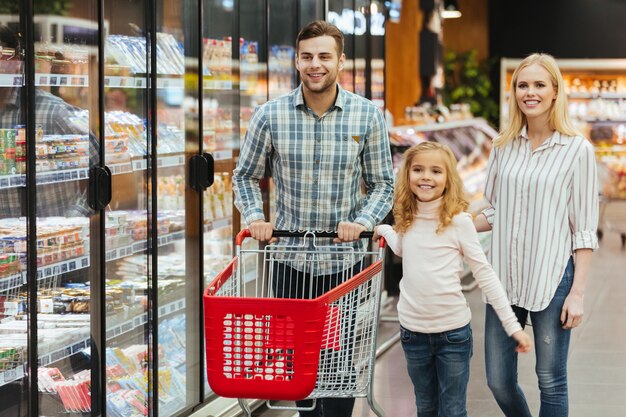 Happy young family with a child walking with a trolley