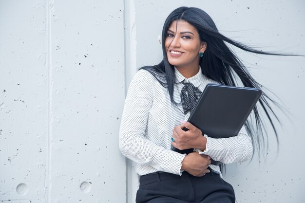 Happy young female entrepreneur with laptop