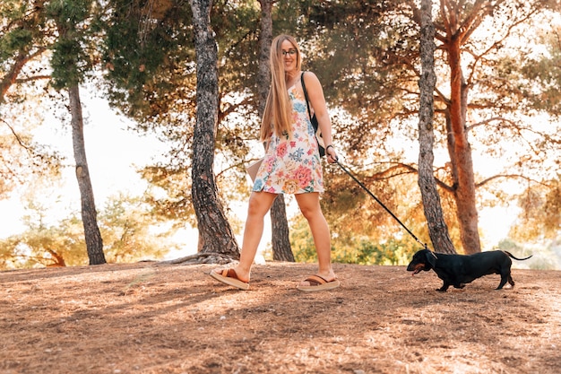 Счастливый молодая женщина, прогуливаясь со своим питомцем в парке