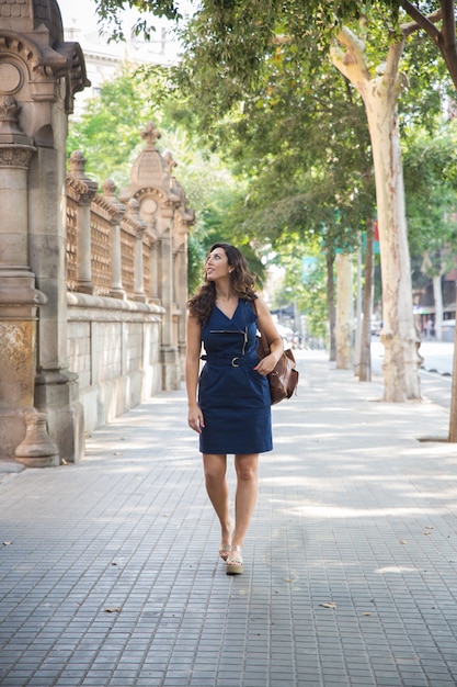 Happy young female traveler going sightseeing