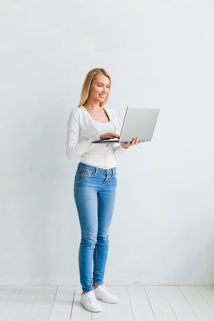 Happy young female working at laptop