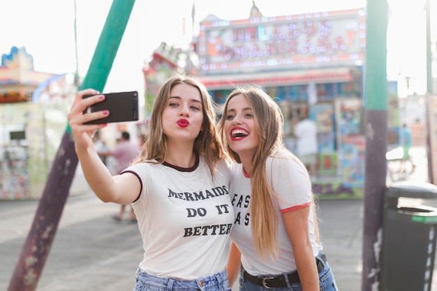 Free photo happy young friends in the amusement park