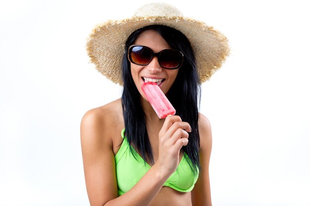 Happy Young girl in bikini, eating an strawberry ice cream