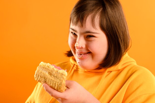 Happy young girl eating delicious cake