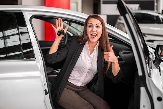 車のキーを保持している幸せな若い女の子