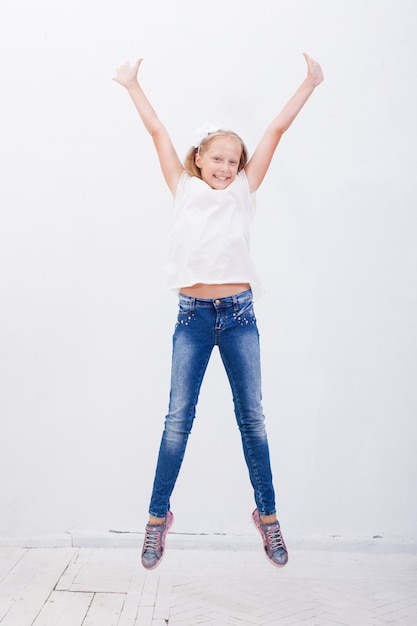 흰색 배경 위에 점프 행복 한 어린 소녀