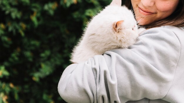 그녀의 고양이와 함께 포즈를 취하는 행복 한 어린 소녀