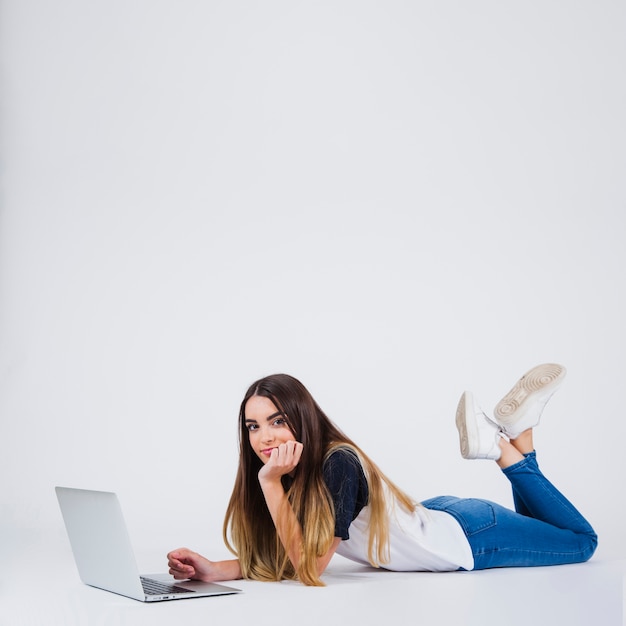 Happy young girl with lap top onthe floor