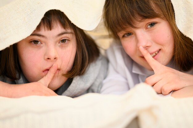 Happy young girls hiding together