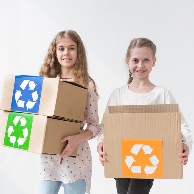 Happy young girls holding recycle boxes