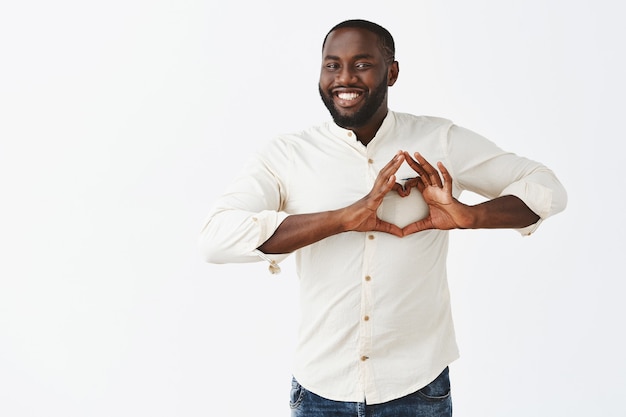 Happy young guy posing against the white wall