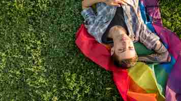 Free photo happy young homosexual lying on glade