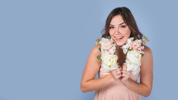 Foto gratuita felice giovane donna in abito con fiori sul collo