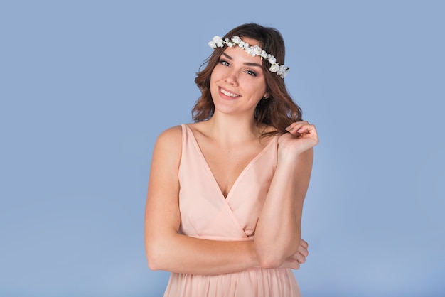 Happy young lady in dress with white wreath on head