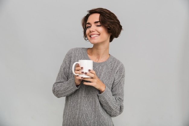 Happy young lady drinking tea.