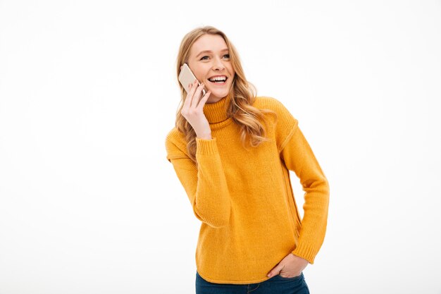 Happy young lady talking by mobile phone.