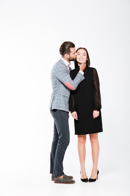 Happy young loving couple standing isolated