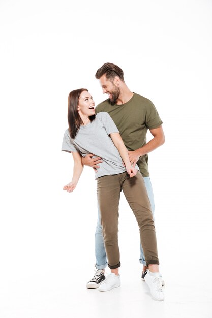 Happy young loving couple standing isolated