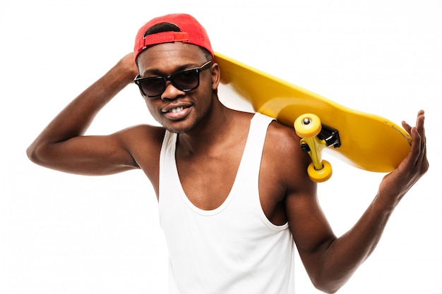 Happy young man in cap and sunglasses with skateboard