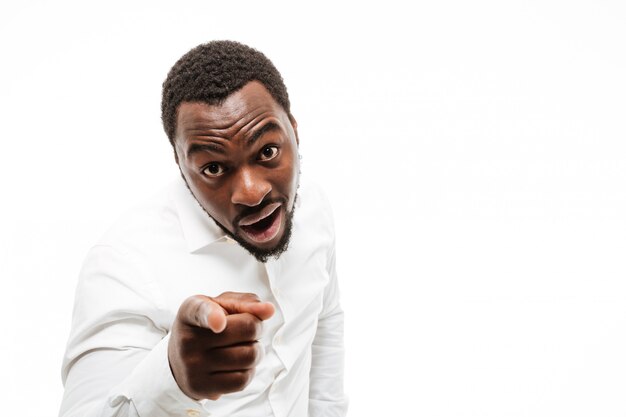 Happy young man dressed in shirt pointing