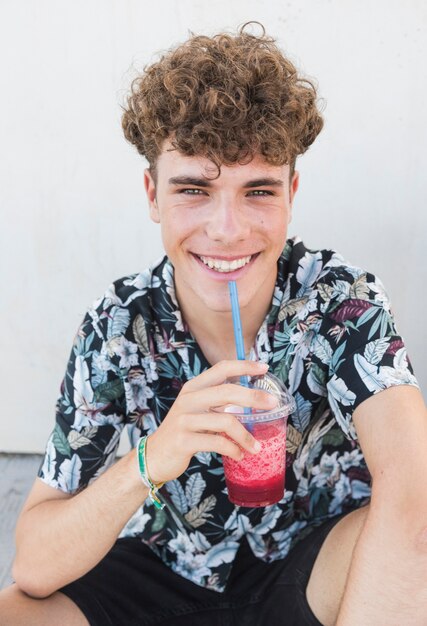 Счастливый молодой человек пить сок