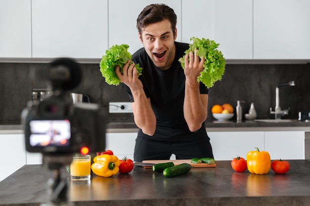 Happy young man filming his video blog episode